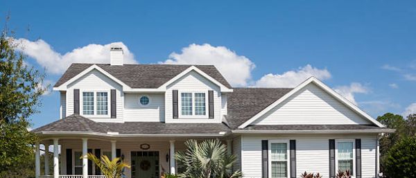 Traditional American home with space for copy; blue sky, extensive front lawn.